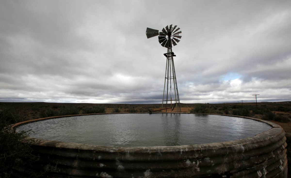 ARCHIVE PHOTO: Storm clouds loom over a borehole windmill near Carnavon in South Africa's remote and arid Northern Cape province in this picture taken May 17, 2012. Reuters/Mike Hutchings