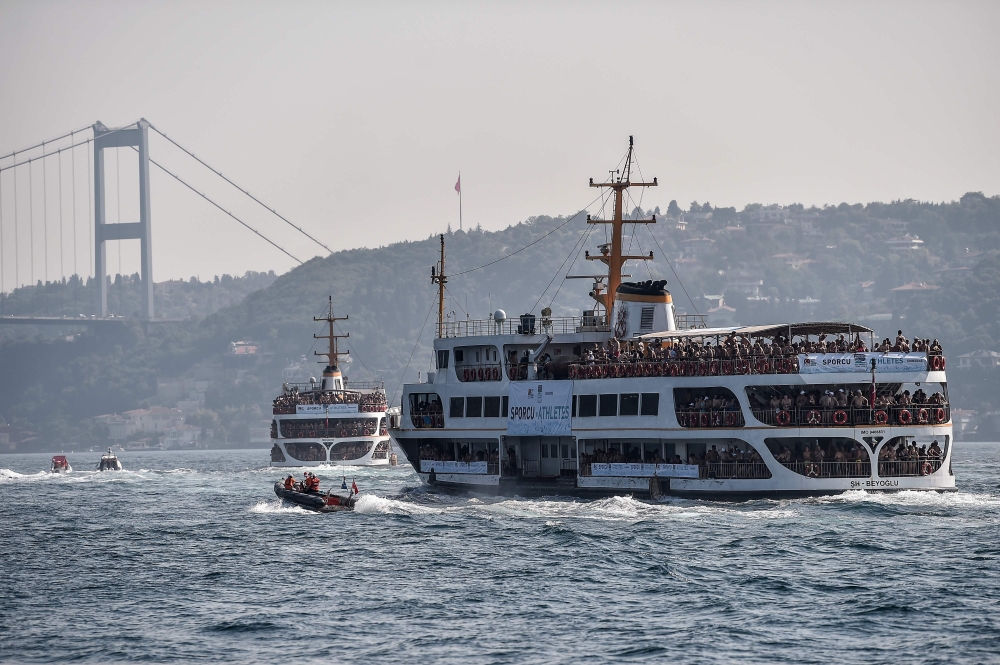 A ferry boat carries swimmers to the start point on the Bosphorous river before taking part in the Bosphorus Cross Continental Swim event on July 22, 2018. The race takes participants 6 kms down the Bosphorus Strait from the Asian side of Istanbul to the 