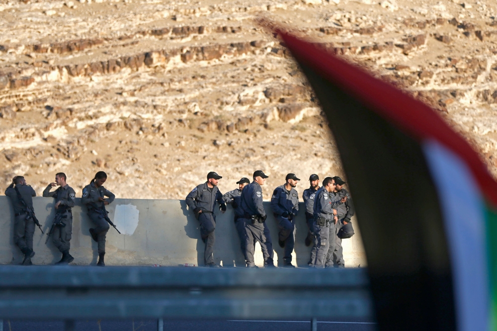Israeli forces stand guard the area as Palestinians demonstrate in support of bedouin inhabitants near their village of Khan al-Ahmar, in the occupied West Bank July 18, 2018. (AFP / ABBAS MOMANI)