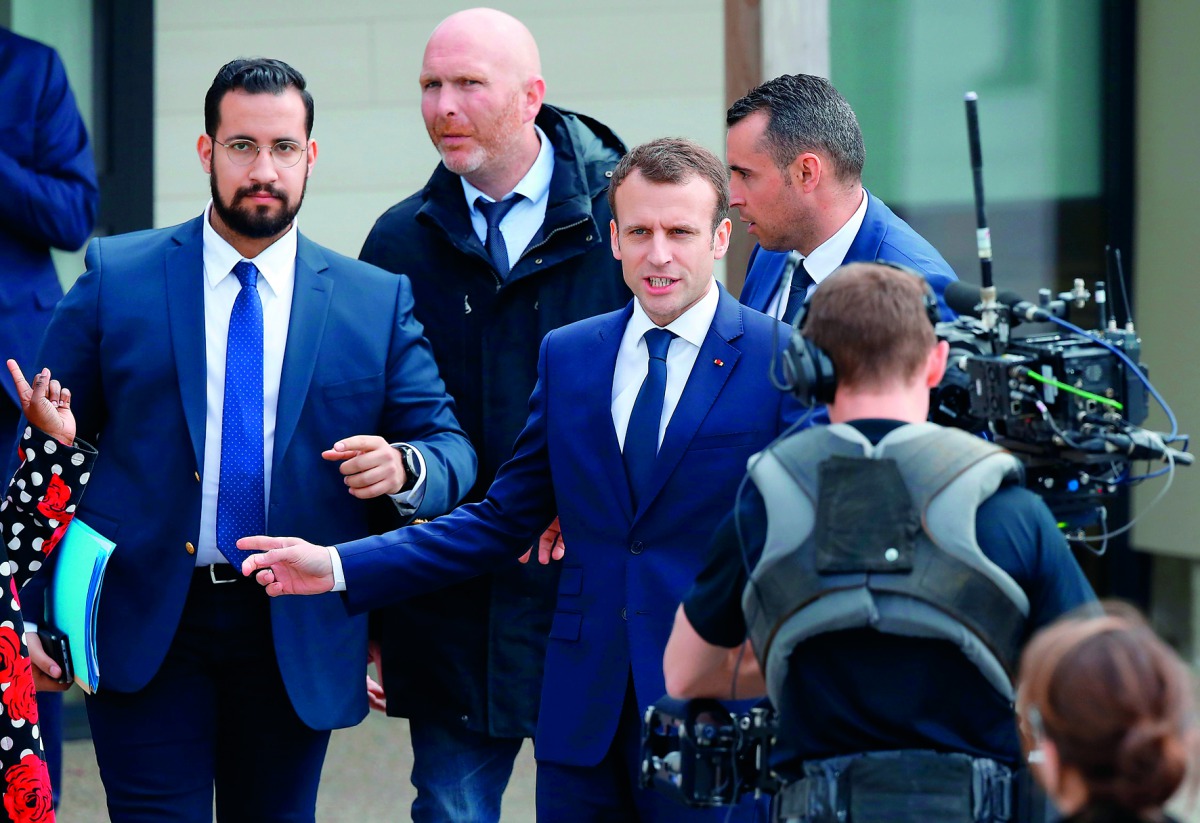 In this file photo taken on April 12, 2018 French President Emmanuel Macron (C), next to Elysee Chief Security Officer Alexandre Benalla (L), arrives at a primary school in Berd'huis, northwestern France, for a television interview in which he is expected