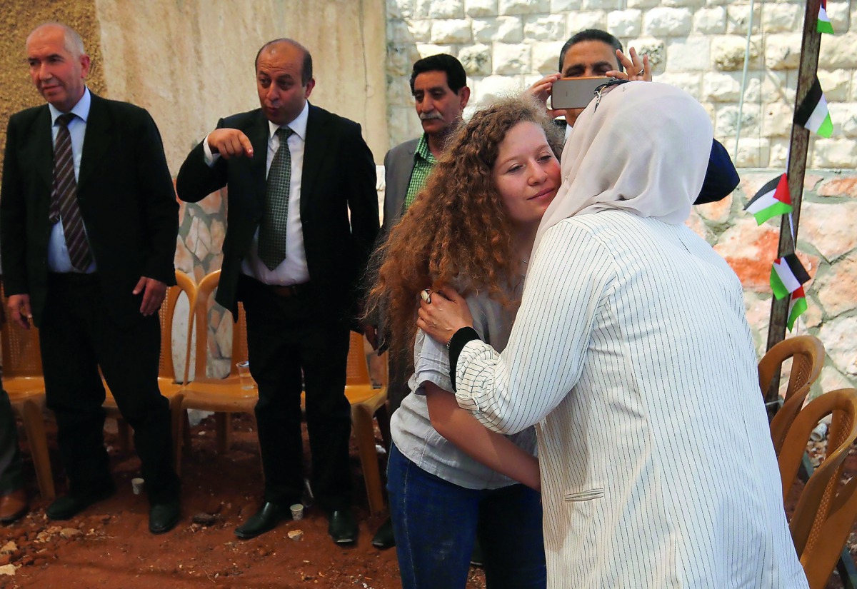 Palestinian activist and campaigner Ahed Tamimi, 17, (2nd R) greets supporters during meeting with the press in the West Bank village of Nabi Saleh on July 30, 2018, following her release from prison. AFP / Abbas Momani