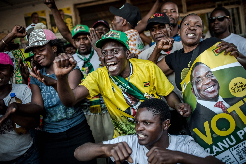 Supporters of the newly reelected Zimbabwe President Emmerson Mnangagwa, celebrate in Mbare, a district of the Zimbabwe's capital Harare on August 3, 2018. / AFP / Luis TATO 