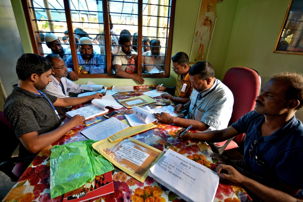 People wait to check their names on the draft list at the National Register of Citizens centre at a village in Nagaon district, Assam state, India, July 30, 2018 (Reuters) 
