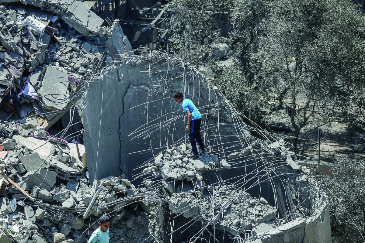 Palestinians inspect the debris of Said Al-Mashal Foundation for Arts and Culture building after yesterday's Israeli airstrikes that hit the cultural center, in western part of Gaza City, Gaza on August 10, 2018. Ali Jadallah/Anadolu Agency