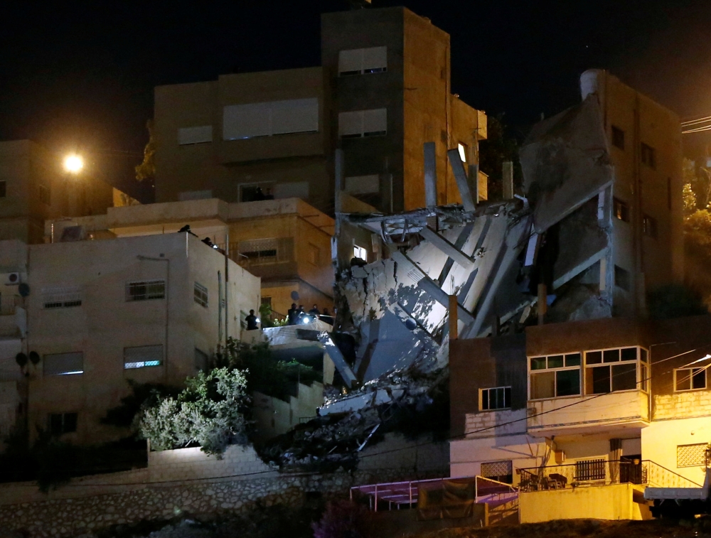 Security forces are seen near a damaged building one day after the security incident, at the city of Al Salt, Jordan, August 11, 2018. Reuters/Muhammad Hamed