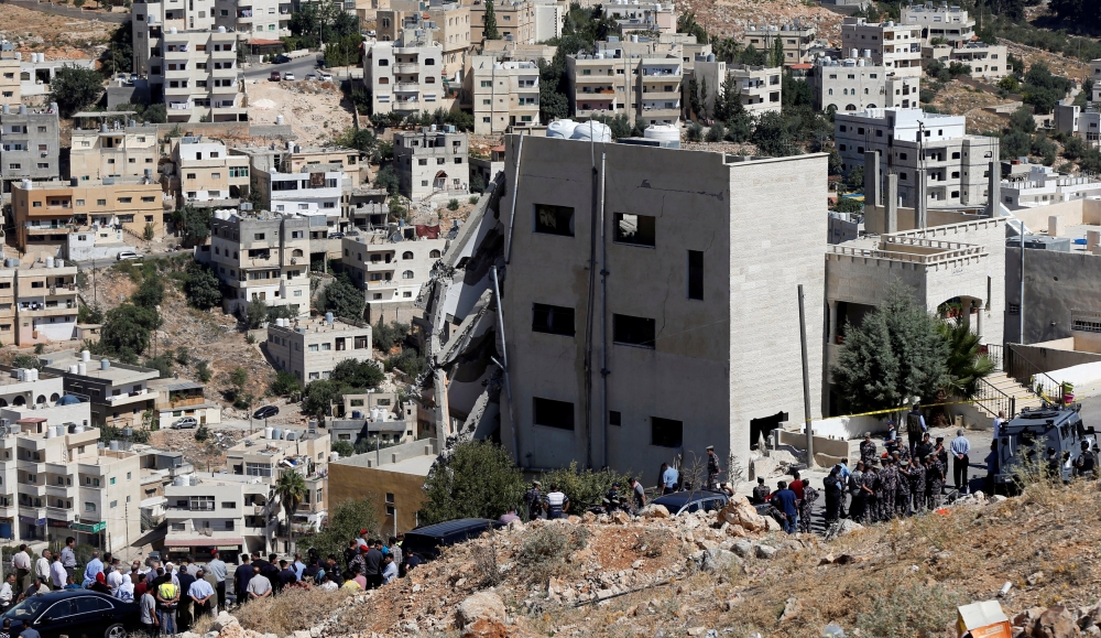 Security forces gather near a damaged building at the city of Salt, Jordan, August 12, 2018. (REUTERS/Muhammad Hamed)
