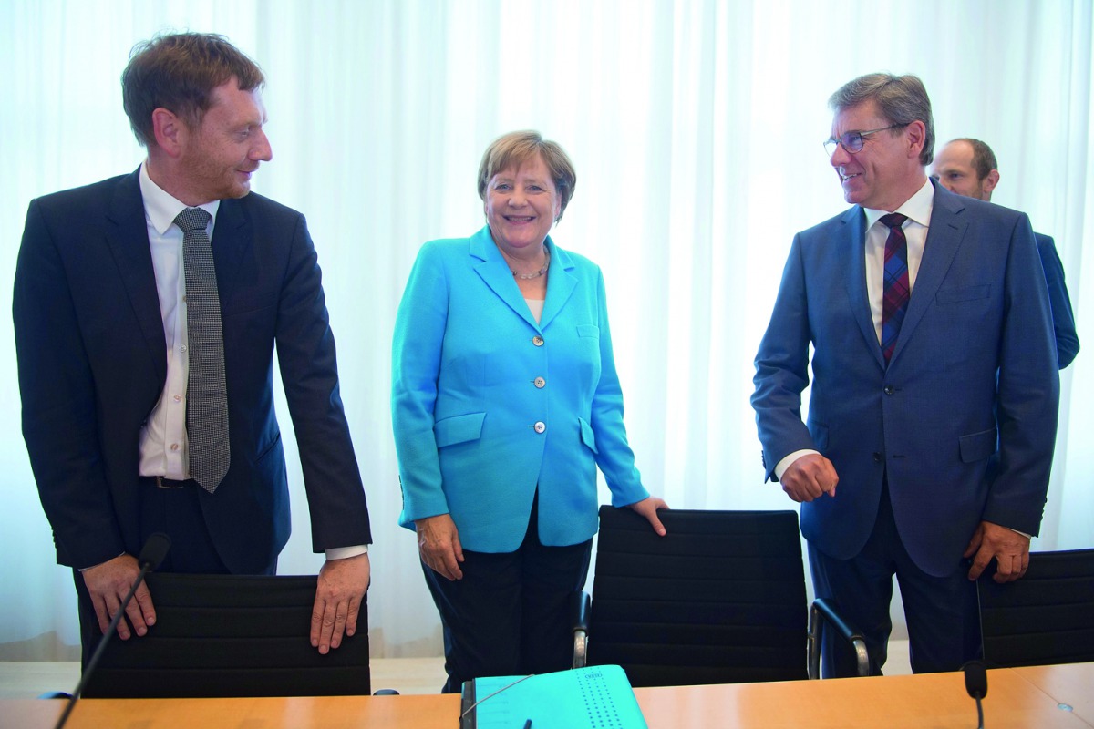  Saxony's Prime Minister Michael Kretschmer, German Chancellor Angela Merkel and parliamentary party leader of the CDU in Saxony Frank Kupfer arrive for a meeting of the CDU party in Saxony state in Dresden, on August 16, 2018. AFP / dpa / Sebastian Kahne