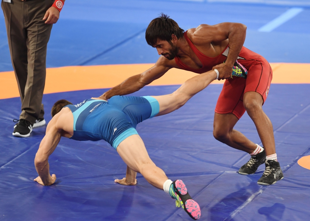 India's Bajrang Bajrang (R) competes with Mongolia's Batmagnai Batchuluun in the men's wrestling freestyle 65kg semi-final at the 2018 Asian Games in Jakarta on August 19, 2018. (AFP / AAMIR QURESHI)