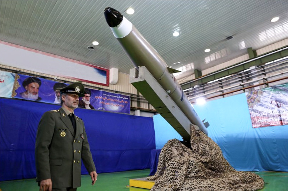A handout picture released by Iran's Defence Ministry on August 13, 2018 shows Defence Minister, Brigadier General Amir Hatami, standing by the next generation short-range ballistic missile 