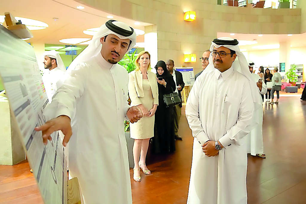 Minister of Energy and Industry H E Dr Mohammed bin Saleh Al Sada looks on as students showcase their work at the Gallery Walk prior to the closing ceremony.