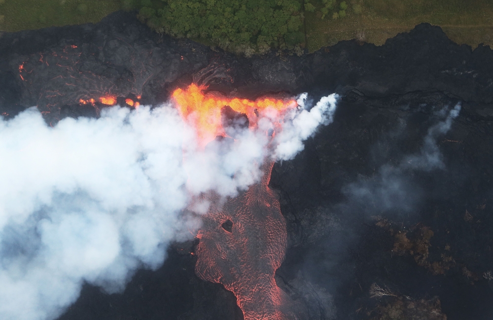 FILE PHOTO: Lava erupts and flows from a Kilauea volcano fissure towards the Pacific Ocean on Hawaii Big Island on May 21 2018 near Pahoa, Hawaii (Mario Tama /Getty Images/AFP) 
