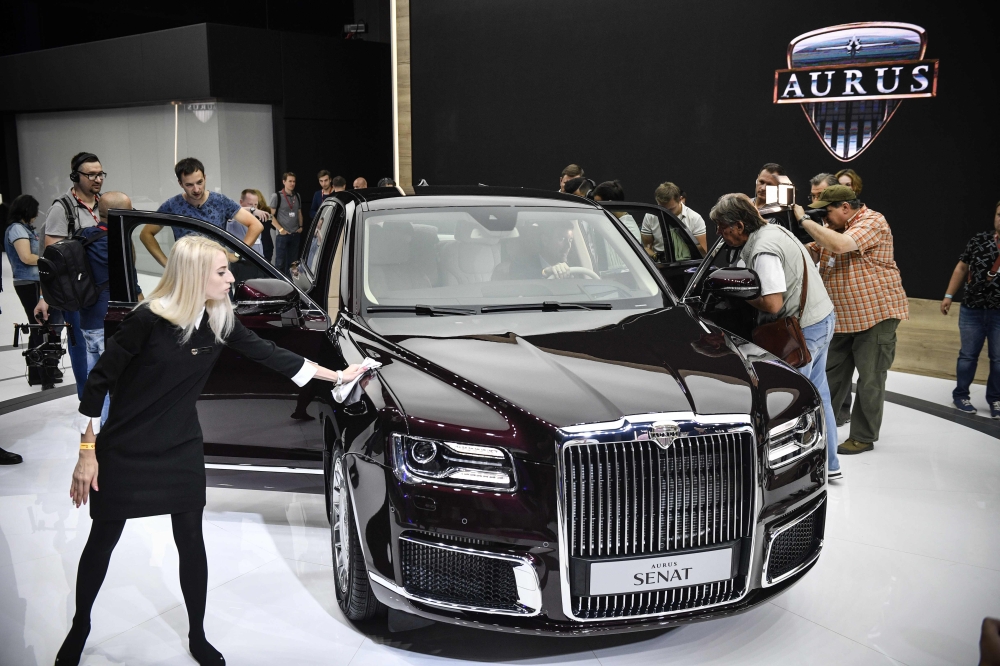Visitors inspect a sedan version of Russian President Vladimir Putin's new Argus Senat limousine at the Moscow International Motor Show in Moscow on August 29, 2018.  AFP / Alexander NEMENOV
