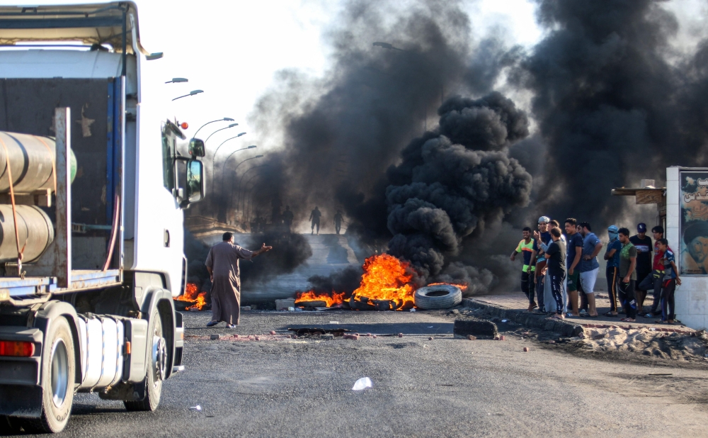 Iraqi protesters burn tires as they block the main road between the centre of the southern city of Basra leading towards Karmat Ali on its northern outskirts on September 2, 2018. / AFP / Haidar MOHAMMED ALI