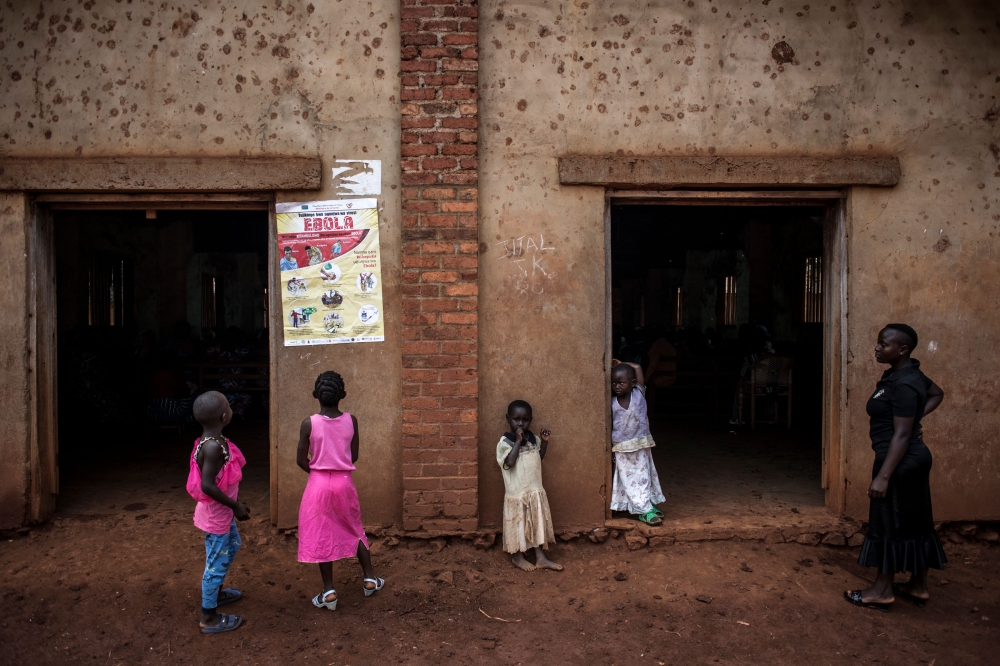 (FILES) In this file photo taken on August 19, 2018 young Congolese girls look at a poster explaining the symptoms of Ebola in Mangina, near Beni, in the North Kivu province. AFP / John WESSELS
