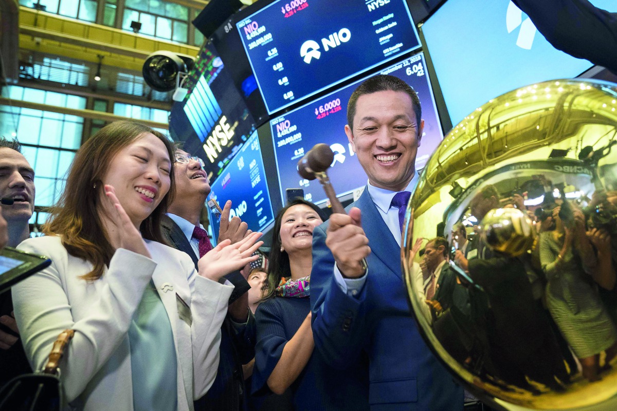 William Bin Lee, chief executive officer and chairman of electric car maker NIO, rings a ball as NIO stock begins trading on the floor of the opening bell at the New York Stock Exchange (NYSE), September 12, 2018 in New York City. The Shanghai-based elect