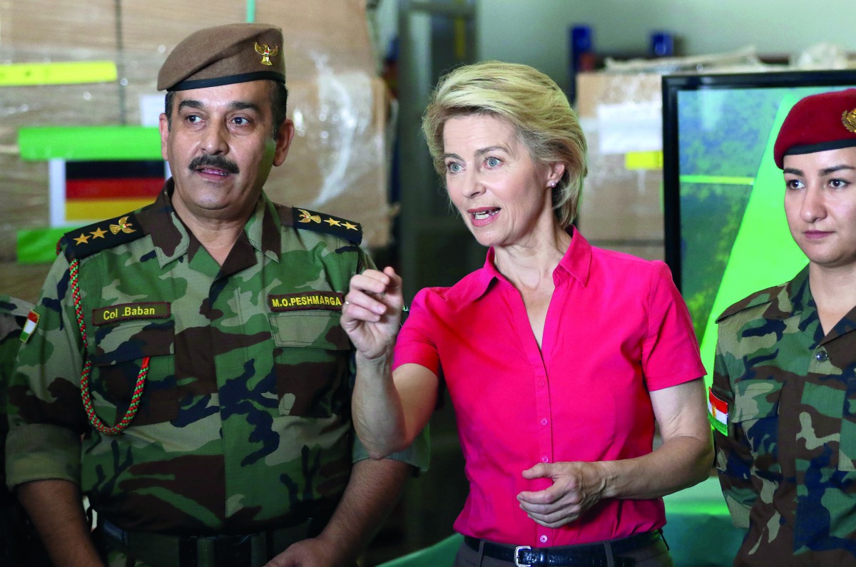 German Defence Minister Ursula von der Leyen (C) speaks to Kurdish Peshmerga fighters during her visit to the military camp of Mirra on the outskirts of Arbil, the capital of the northern Iraqi Kurdish autonomous region on September 17, 2018. AFP / Safin 