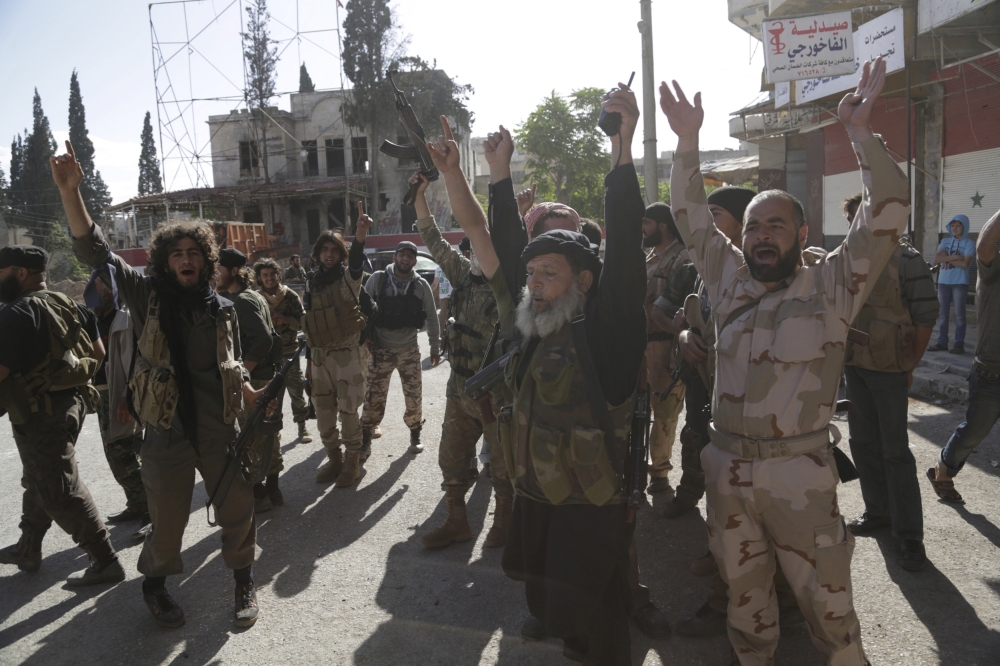 FILE PHOTO: Members of al Qaeda's Nusra Front gesture as they cheer in the northwestern city of Ariha, after a coalition of insurgent groups seized the area in Idlib province May 29, 2015. REUTERS/Khalil Ashawi
