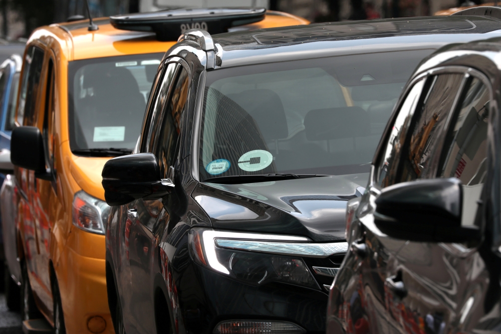 FILE PHOTO: An Uber car drives in traffic on 6th Avenue in New York City, New York, U.S., July 27, 2018. REUTERS/Mike Segar
