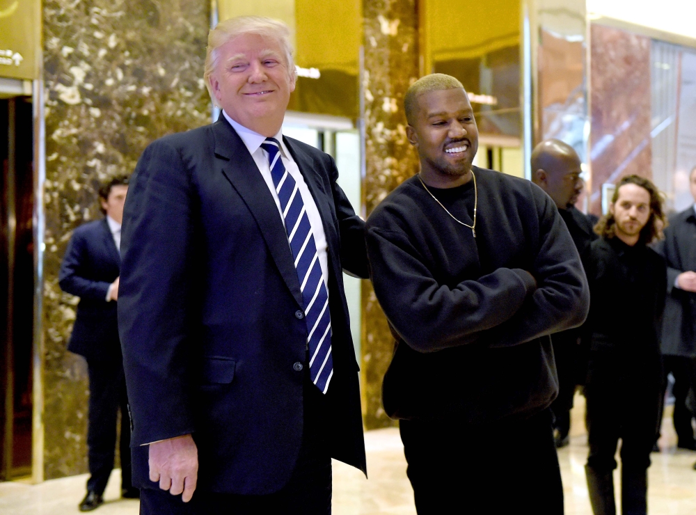 This file photo taken on December 13, 2016 shows US singer Kanye West (R) and then-president-elect Donald Trump speaking with the press after their meetings at Trump Tower in New York. / AFP / TIMOTHY A. CLARY 