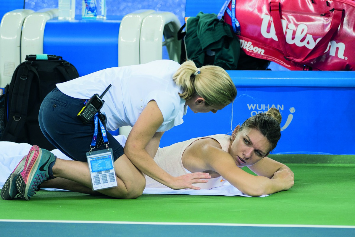 

 
Simona Halep (R) of Romania gets medical treatment as she plays against Dominika Cibulkova of Slovakia during their women's singles third round match of the WTA Wuhan Open tennis tournament in Wuhan on September 25, 2018. AFP / Nicolas Asfouri 

