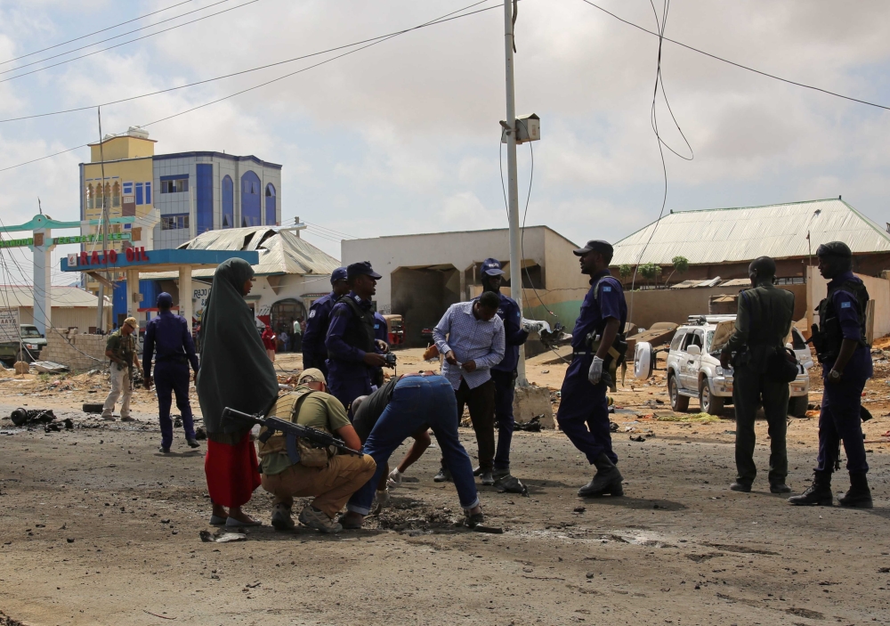 Somalian security officials investigate the scene after a suicide attack carried out with a bomb-laden vehicle during the passing of Italian military convoy on October 01, 2018 in Mogadishu, Somalia. Sadak Mohamed - Anadolu 