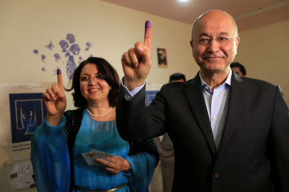 Barham Salih, Former Prime Minister of Iraq's Kurdistan Regional Government and Head of the Coalition for Democracy and Justice with his wife show their ink-stained fingers after casting their votes at a polling station during the parliamentary election i