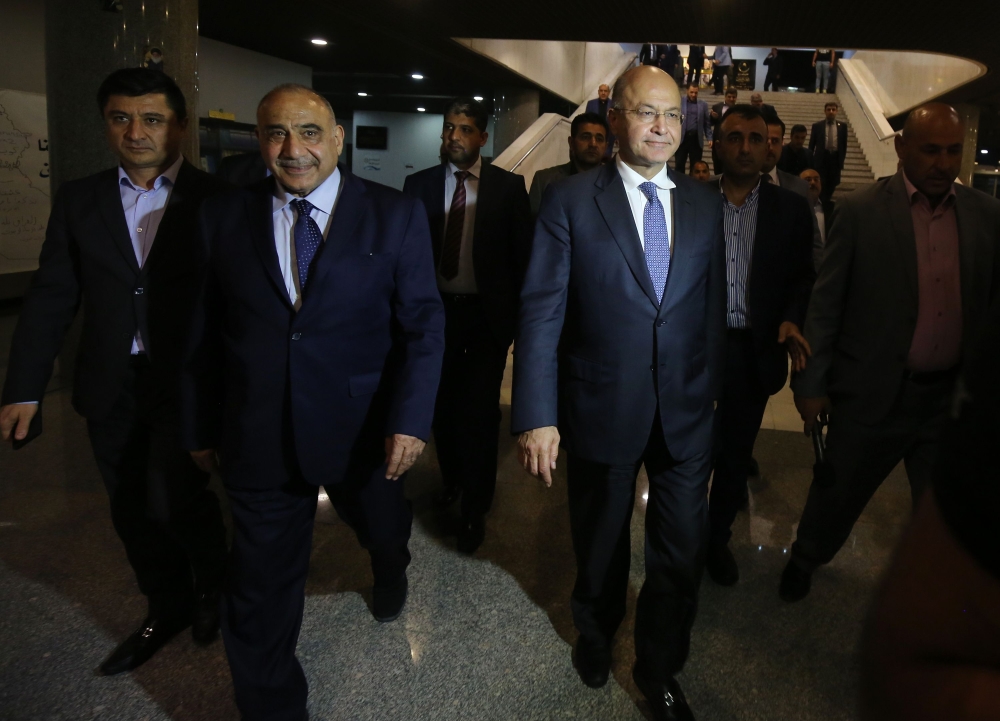 Newly designated Iraqi Prime Minister Adel Abdul Mahdi (2nd L) walks out of the Parliament with newly-elected Iraqi President Barham Saleh (R). / AFP / AHMAD AL-RUBAYE