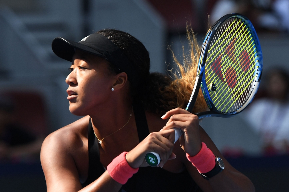 Naomi Osaka of Japan hits a return during her women's singles third round match against Julia Goerges of Germany at the China Open tennis tournament in Beijing on October 4, 2018. / AFP / GREG BAKER