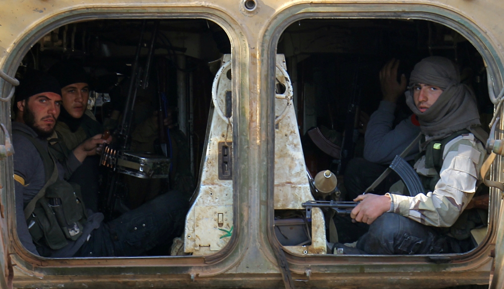 FILE PHOTO: Rebel fighters ride a military vehicle with their weapons in Dahiyet al-Assad, west Aleppo city, Syria October 30, 2016. REUTERS/Ammar Abdullah