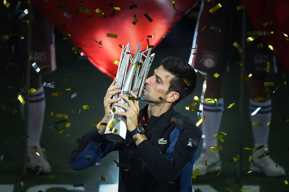 Serbia's Novak Djokovic kisses the trophy after winning his men's final singles match against Croatia's Borna Coric at the Shanghai Masters tennis tournament in Shanghai on October 14, 2018. / AFP / WANG Zhao