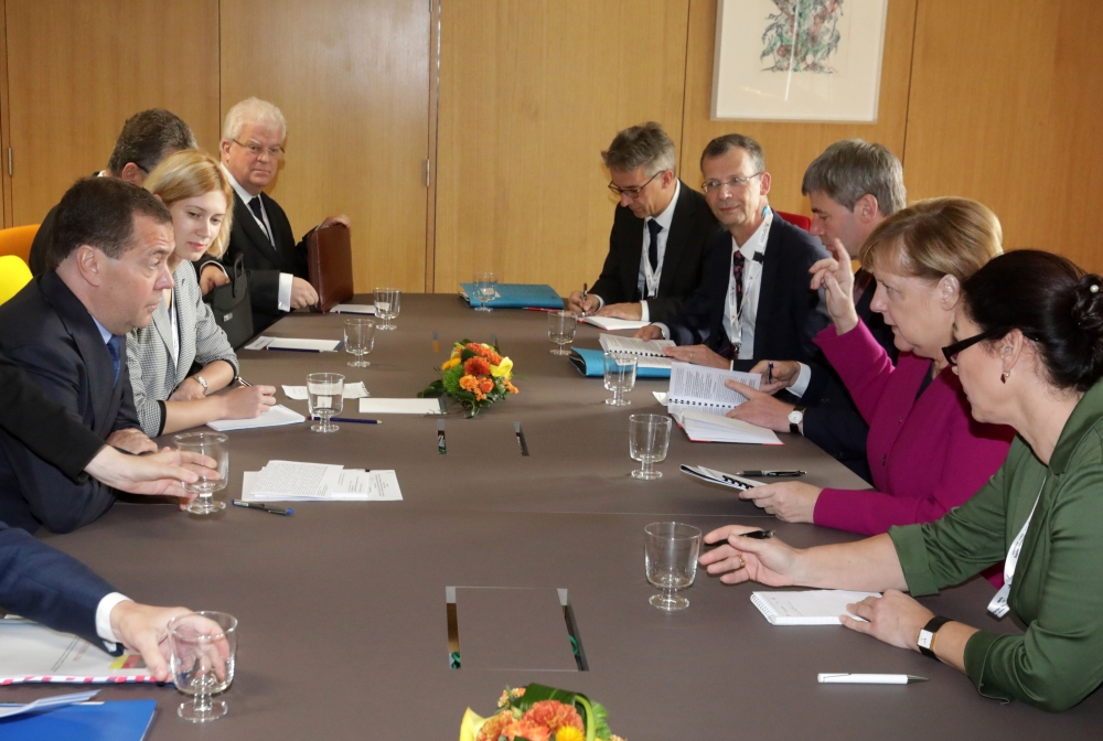 German Chancellor Angela Merkel (2R) meets with Russia's Prime Minister Dmitry Medvedev (L) during a meeting on the sidelines of an EU-ASEM leaders meeting at the European Council in Brussels on October 19, 2018. / AFP / POOL / Olivier Matthys