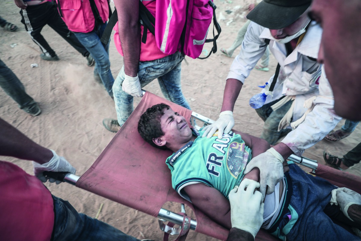 A wounded Palestinian child is being evacuated from the site after Israeli soldiers' intervention during the 