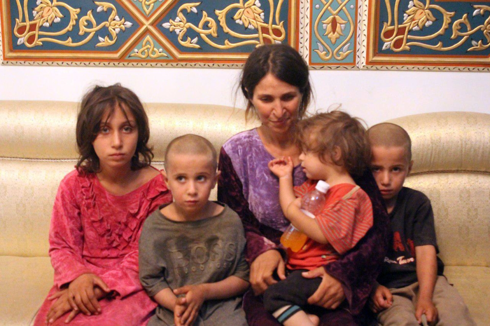 A handout picture released by the official Syrian Arab News Agency (SANA) on October 20, 2018 shows a woman and four children among the six released of 27 Druze hostages held by the Islamic State (IS) group in a prisoner swap and ransom, upon their arriva