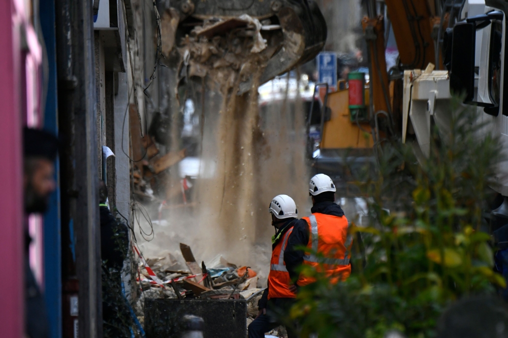Workers renove the rubble at the site where two buildings collapsed, on November 6, 2018 in Marseille. French rescue workers were searching into the night Monday for possible victims under the wreckage of two dilapidated buildings that suddenly collapsed 