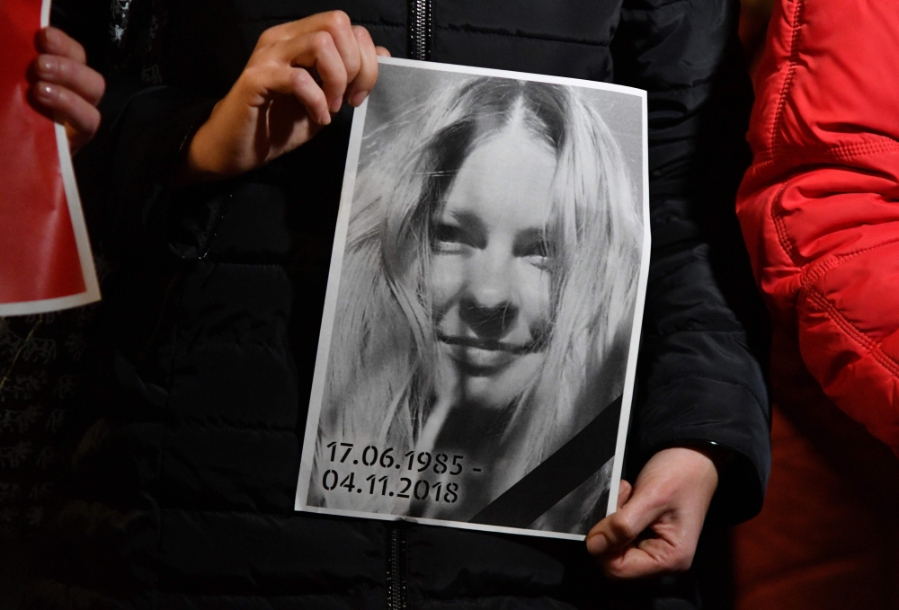 People hold a portrait of Gandyuk in front of the Ministry of Internal Affairs of Ukraine in remembrance of Ukrainian anti-corruption campaigner Kateryna Gandzyuk, seriously injured in an acid attack in July 2018 and who died in the hospital today, in Kie