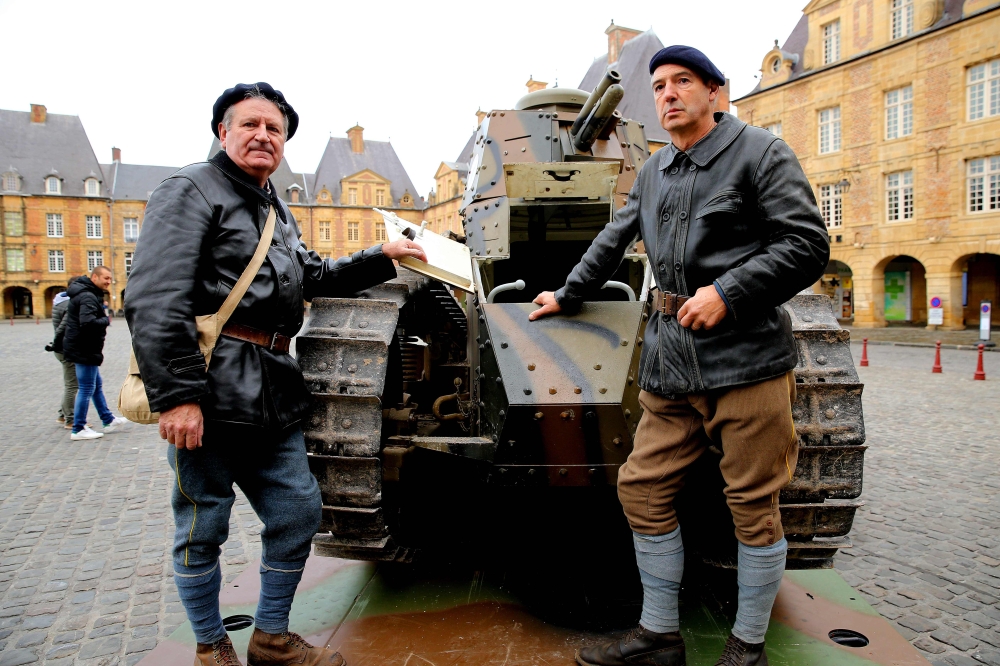 Two tank drivers pose with a Renault 17 tank on Place Ducale in Charleville-Mezieres, north-western France, on November 7, 2018, as French President Emmanuel Macron visits the Ardennes, a symbolic department of the Great War.   AFP / FRANCOIS NASCIMBENI

