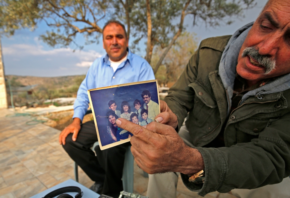 The uncle of Rashida Tlaib, the winner of Michigan's 13th congressional district in the 2018 US general election, displays a picture of her in the village of Bayt Or al Fawqa, in the occupied West Bank on November 8, 2018.  AFP / Abbas Momani 

 