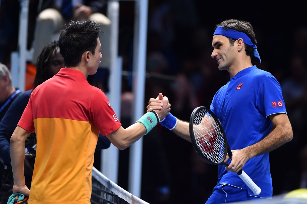 Japan's Kei Nishikori (L) greets Switzerland's Roger Federer after winning their singles round robin match 7-6, 6-3 on day one of the ATP World Tour Finals tennis tournament at the O2 Arena in London on November 11, 2018. AFP / Glyn Kirk