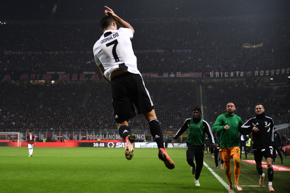 Juventus' Portuguese forward Cristiano Ronaldo celebrates after scoring during the Italian Serie A football match AC Milan vs Juventus on November 11, 2018 at the San Siro stadium in Milan. / AFP / Marco BERTORELLO