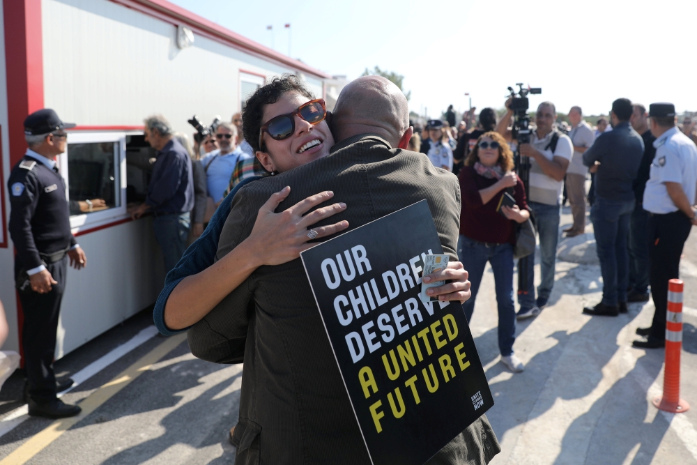 People hug each other at newly opened checkpoint linking the Greek and Turkish Cypriot communities in Dherinia, Cyprus November 12, 2018. REUTERS/Yiannis Kourtoglou