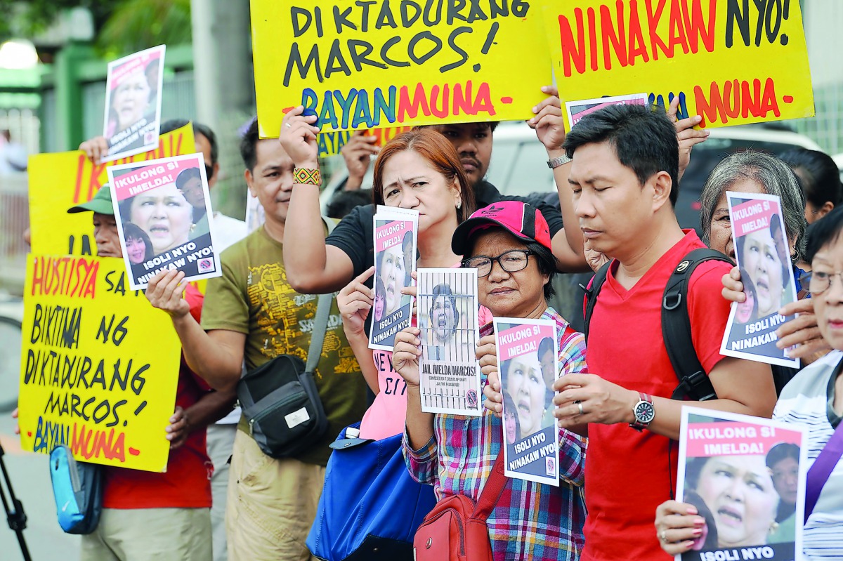 Anti-Marcos demonstrators display placards with portraits of Philippines' former first lady Imelda Marcos during a protest in front of the anti-graft court in Manila on November 13, 2018.  AFP / Ted Aljibe 
