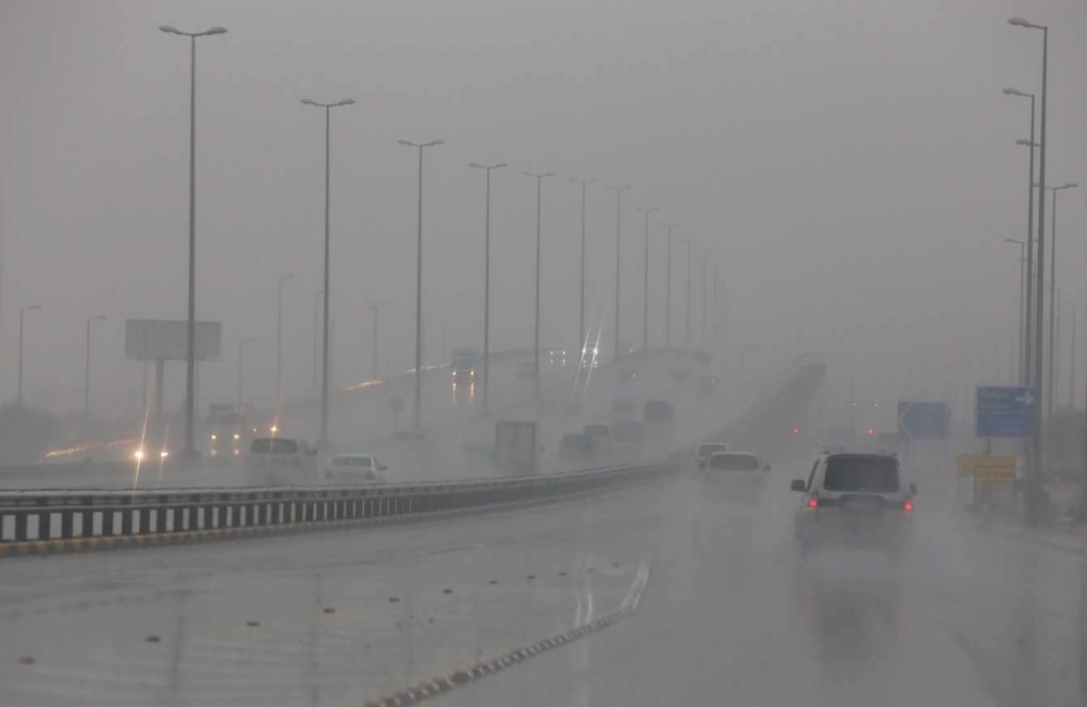 Cars put on their lights as they drive through rain and mist in Kuwait City in stormy weather on November 14, 2018, four days after flash floods hit the Gulf emirate, killing a man and causing damage to roads, bridges and homes. / AFP / Yasser Al-Zayyat
