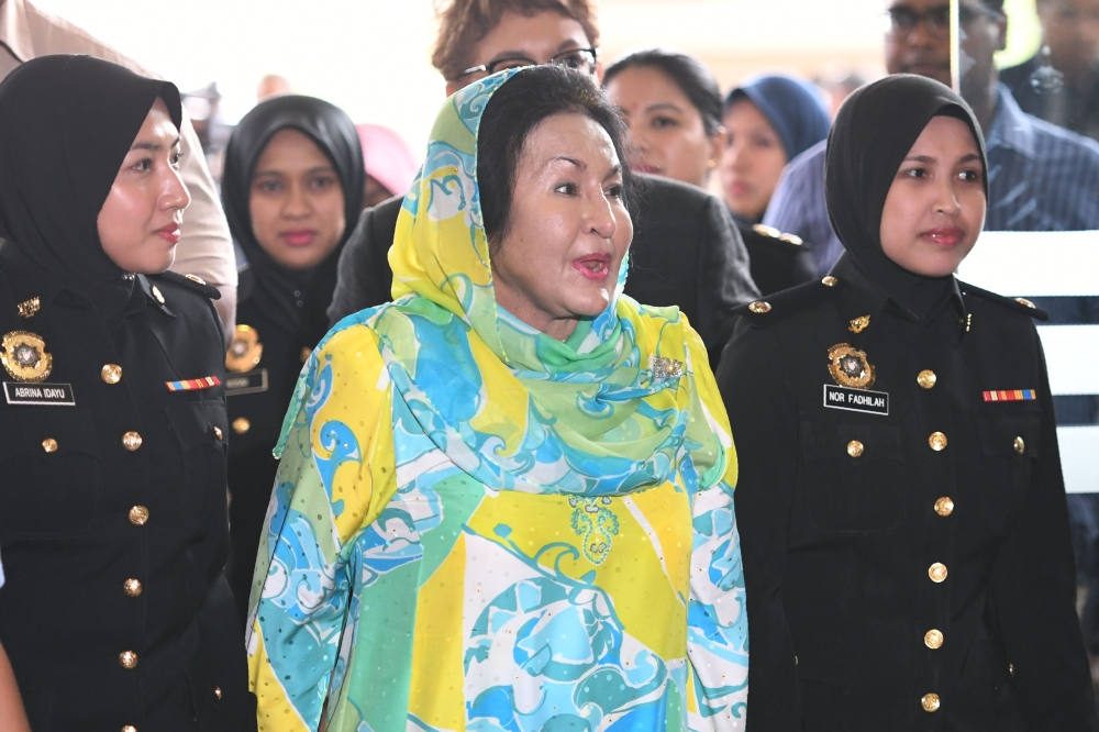 Rosmah Mansor wife of former Malaysian prime minister Najib Razak (C), is escorted by police personnel during her arrival at court in Kuala Lumpur on November 15, 2018. / AFP / MOHD RASFAN 