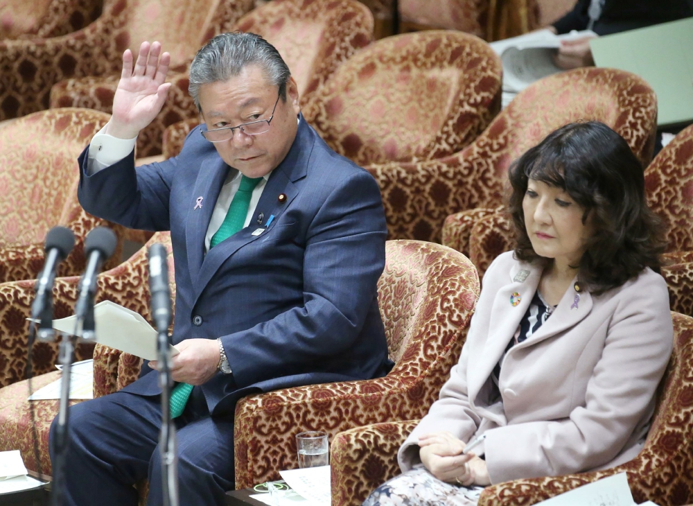 Yoshitaka Sakurada (L), 68, the deputy chief of the government's cyber security strategy office raising his hand to answer a question beside Satsuki Katayama (R), minister in charge of regional revitalisation and female empowerment, during a parliament se