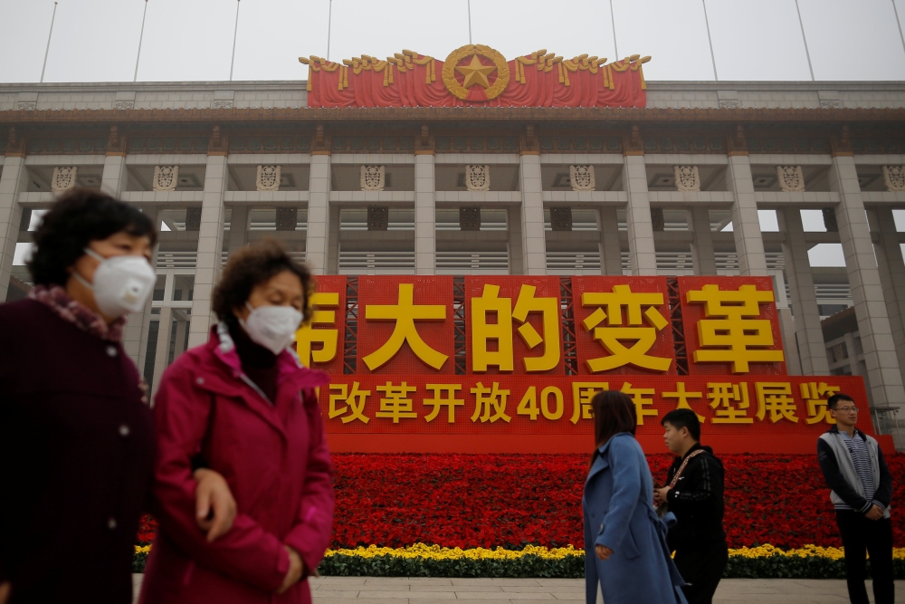 Visitors wear face masks on a polluted day outside an exhibition marking the 40th anniversary of China's reform and opening up at the National Museum of China in Beijing, China November 14, 2018. REUTERS/Thomas Peter