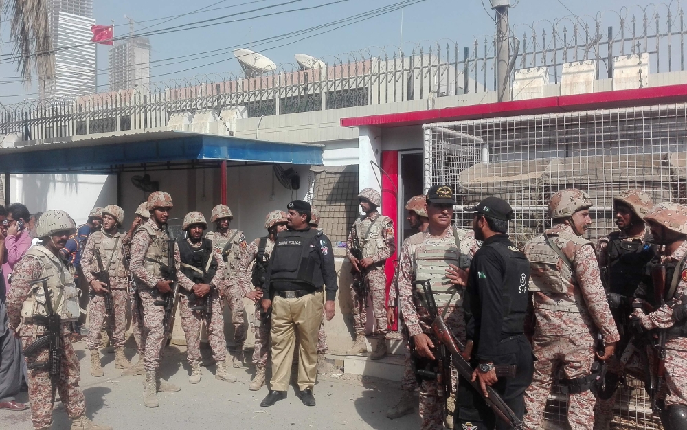 Pakistani security personnel stand outside the Chinese consulate after an attack in Karachi on November 23, 2018.  / AFP / ASIF HASSAN 