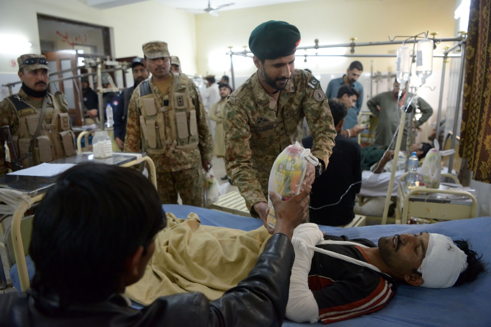 A Pakistani army soldier distributes drinks to suicide blast victims in a hospital in Kohat on November 23, 2018. AFP / Abdul Majeed
