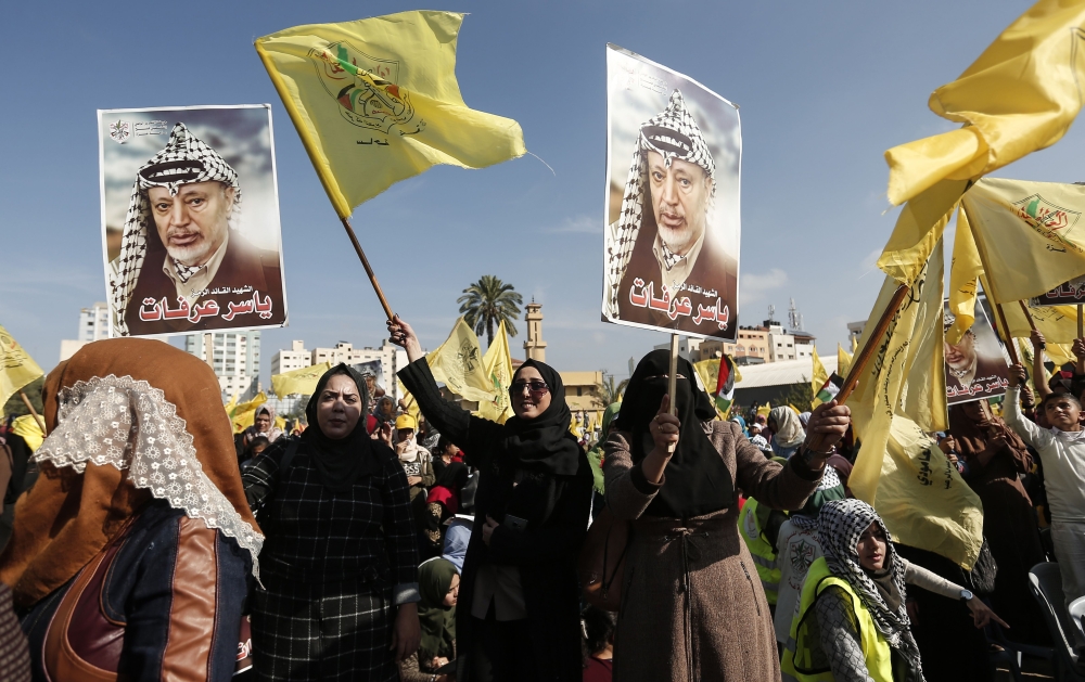 Supporters of Fatah movement's former security chief, Mohammed Dahlan, hold images of late Palestinian leader Yasser Arafat during a commemoration ceremony held on the occasion of the 14th anniversary of Arafat's death, on November 20, 2018 in Gaza city. 