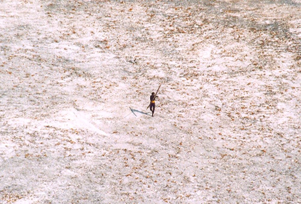 File photo of a Sentinel tribal man aims with his bow and arrow at an Indian Coast Guard helicopter as it flies over the island for a survey of the damage caused by the tsunami in India's Andaman and Nicobar archipelago, December 28, 2004. REUTERS/Indian 