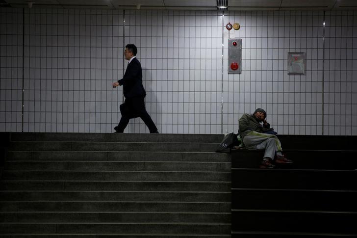 A man walks past a homeless man at an underground shopping district in Seoul, South Korea, July 12, 2016. Reuters/Kim Hong-Ji